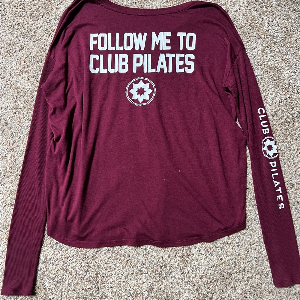 Club Pilates Maroon long sleeve. Slight cracking on letters on back. Medium.